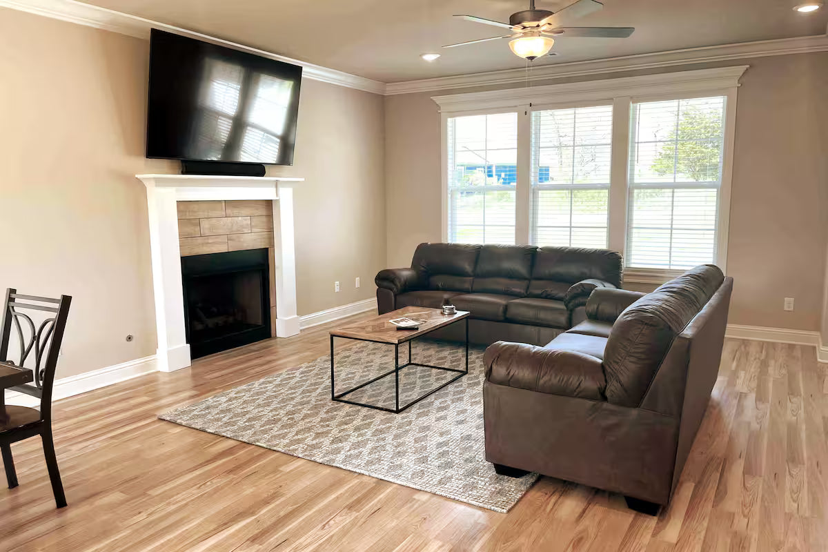 Living room with brown sectional sofa, coffee table, and fireplace in Woodland Retreat, Holiday Island