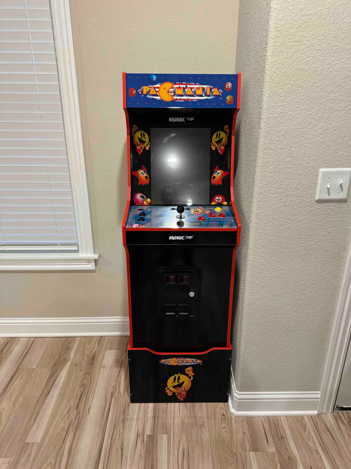 Arcade machine with Pac-Man design on a wooden floor. Woodland Retreat, Holiday Island.