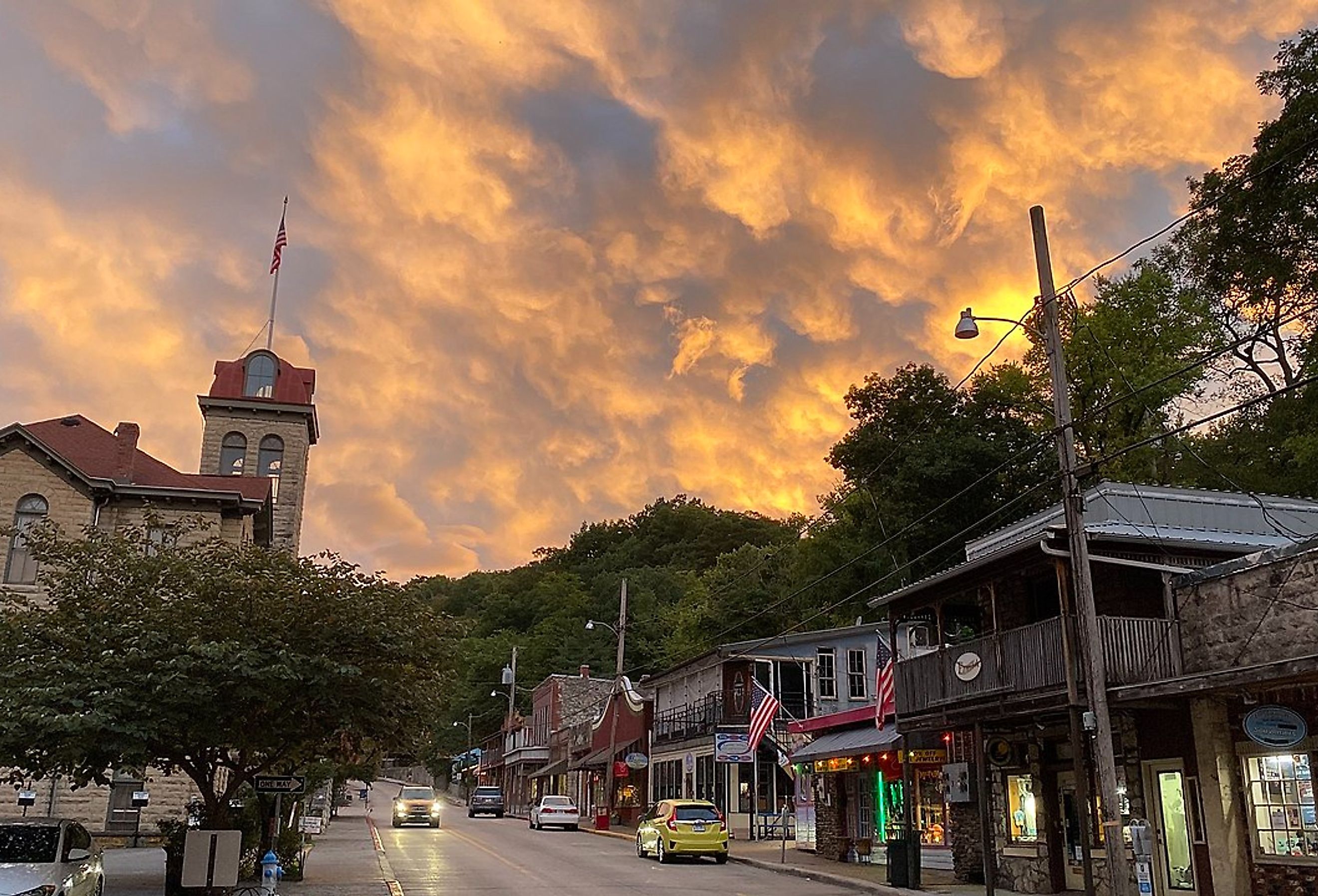 Small town street with a clock tower under a vibrant sunset sky in Eureka Springs