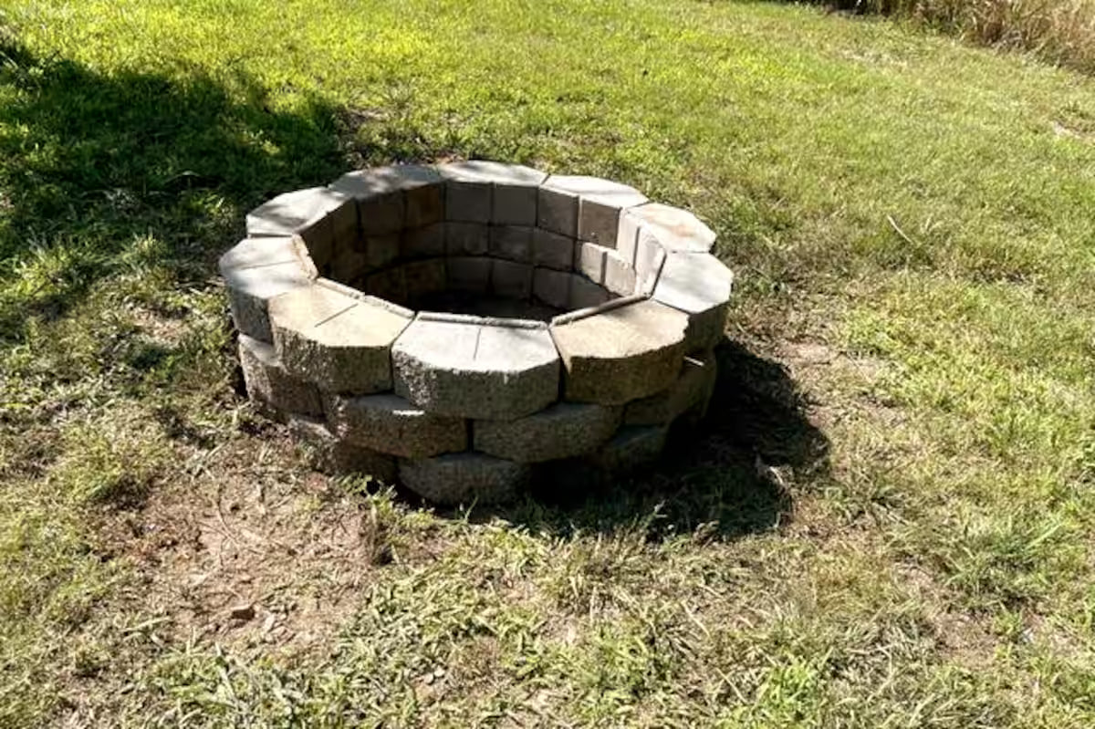 Stone fire pit in a grassy outdoor area